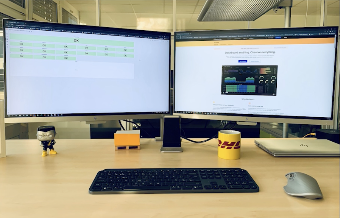*A quick look at Grafana dashboards gives the DHL Express team a comprehensive view of the status of their systems and processes – and the ability to enjoy that first cup of coffee each morning.* Screenshot of computer monitors showing Grafana dashboard and grafana.com.